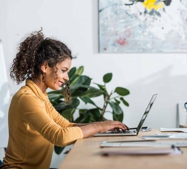 a young woman is typing content on her laptop