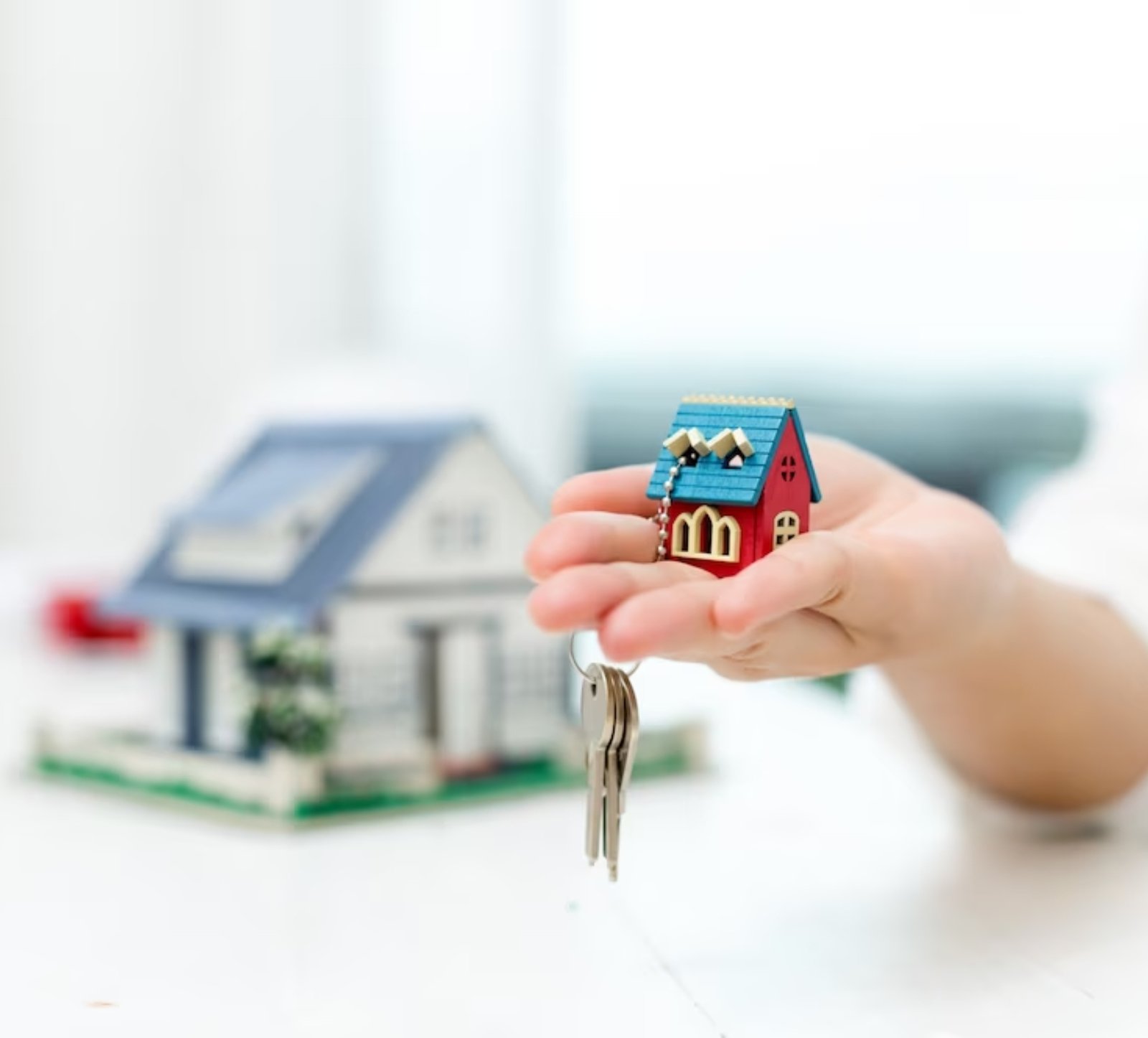 real estate agent with house model and keys