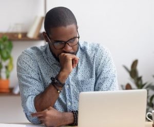 a worried person looking at the laptop