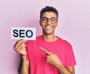 young boy holding a piece of paper with seo written on it